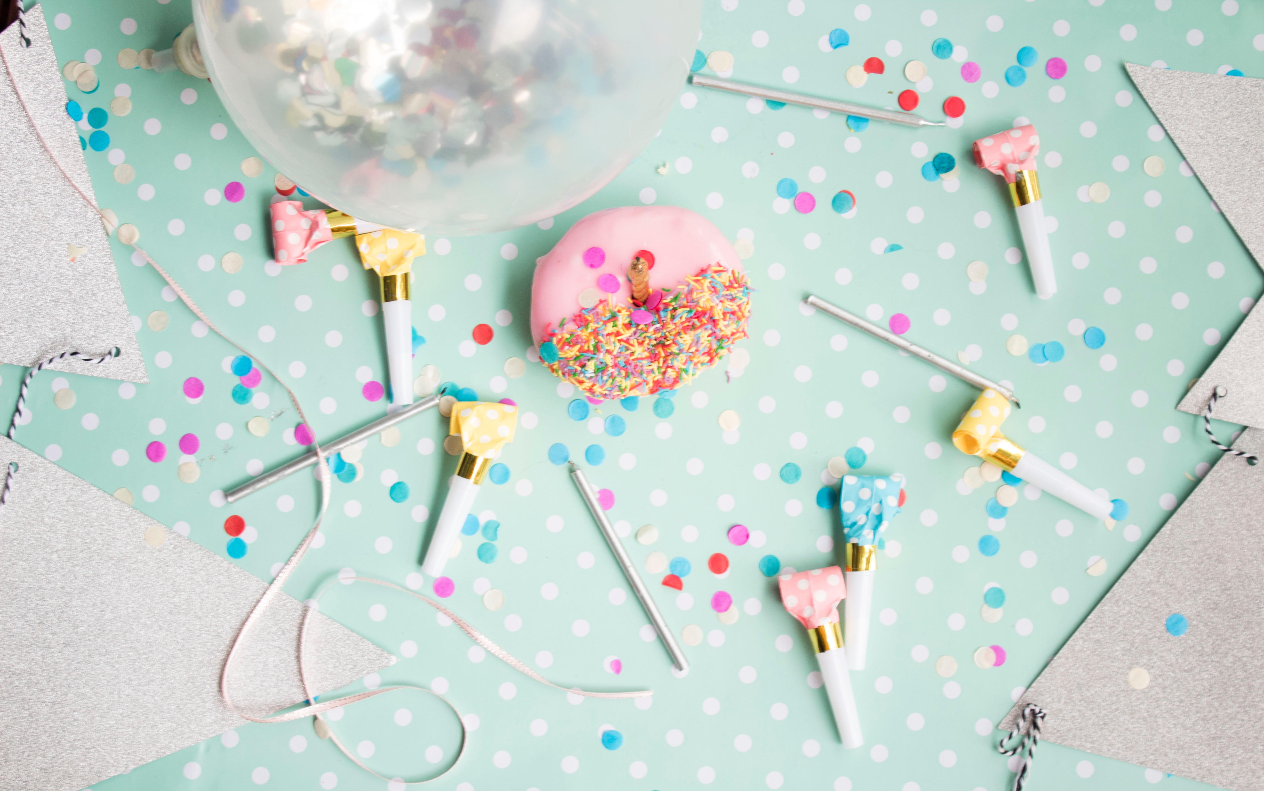 Kids party scene with confetti, donuts and balloon