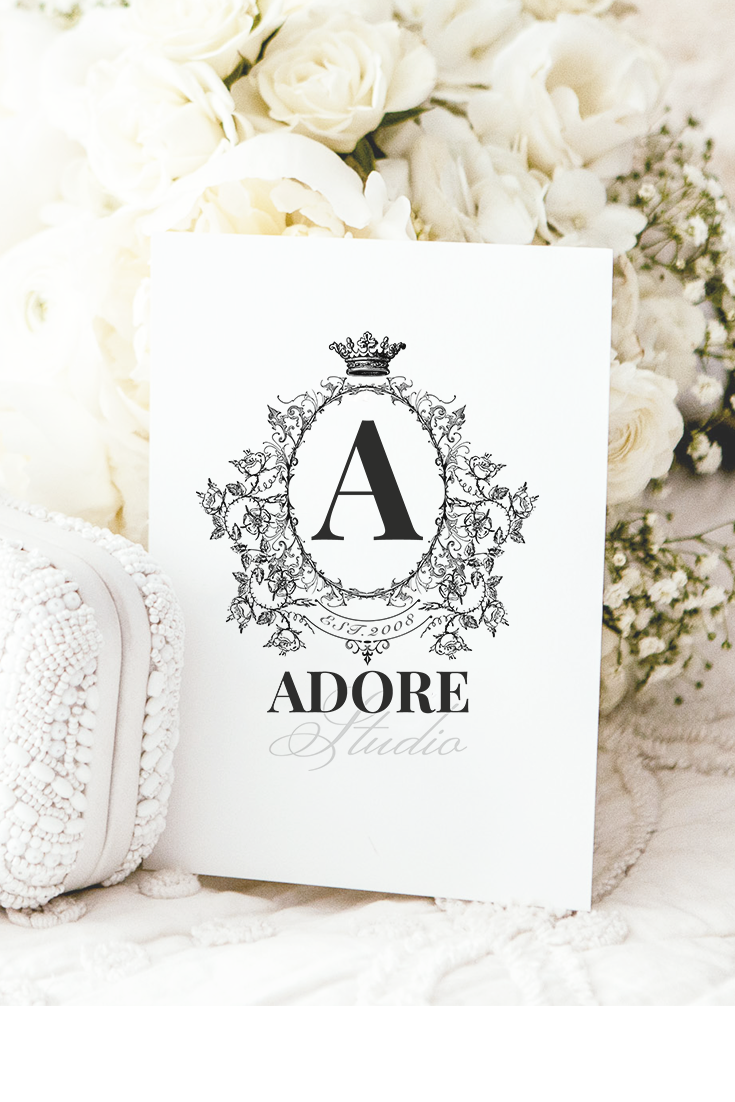 White roses on bed with white clutch and Adore logo